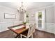 Bright dining room with a wooden table, white chairs, elegant chandelier, and large windows for natural light at 60 Bartlett Way, Dallas, GA 30157
