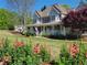 Picturesque home featuring a well-manicured lawn, vibrant flowers, and a welcoming front porch at 60 Bartlett Way, Dallas, GA 30157