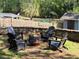 Outdoor stone firepit with seating area surrounded by lush greenery and a storage shed at 60 Bartlett Way, Dallas, GA 30157
