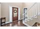 Inviting foyer features a decorative glass front door, hardwood floors, and staircase with white railing at 60 Bartlett Way, Dallas, GA 30157