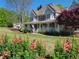 Charming two-story home boasting a welcoming front porch, lush landscaping, and traditional design elements at 60 Bartlett Way, Dallas, GA 30157