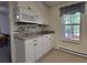 Compact kitchenette features bright white cabinets, sink, and stainless microwave at 60 Bartlett Way, Dallas, GA 30157