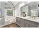Bathroom with a double sink vanity, a soaking tub under a window, and wood look tile floors at 60 Bartlett Way, Dallas, GA 30157