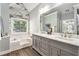 Bright main bathroom with double sink vanity, soaking tub, and wood-look tile flooring at 60 Bartlett Way, Dallas, GA 30157