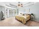 Spacious main bedroom features a tray ceiling, neutral carpet, and bay windows offering lots of natural light at 60 Bartlett Way, Dallas, GA 30157