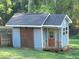 Backyard outbuilding with a gable roof, stone accents, sliding barn door and classic painted siding at 60 Bartlett Way, Dallas, GA 30157