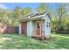 Exterior view of the backyard outbuilding with a stone foundation and rolling door at 60 Bartlett Way, Dallas, GA 30157
