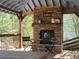 A covered outdoor living space features a stone fireplace and wood beams at 60 Bartlett Way, Dallas, GA 30157