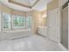 Large primary bathroom featuring a soaking tub, double windows, and white tile floors at 770 Raleigh Sw Ct, Marietta, GA 30064