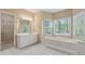 Bathroom featuring a soaking tub, double windows, vanity, and white tile floors at 770 Raleigh Sw Ct, Marietta, GA 30064