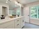 Modern bathroom featuring double sinks, a large mirror, and windows for natural light at 116 Winsome Way, Woodstock, GA 30188