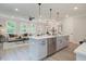 Bright, open-concept kitchen features a large island, modern appliances, and seamless flow into the living area at 116 Winsome Way, Woodstock, GA 30188