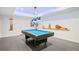 Basement game room featuring a blue pool table with overhead lighting and a guitar displayed on the wall at 2564 Walden Estates Dr, Marietta, GA 30062