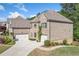 Imposing brick house with 3-car garage and driveway nestled among mature trees and landscaping at 2564 Walden Estates Dr, Marietta, GA 30062