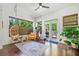 Inviting sunroom with unique hanging chair, cozy seating area, wood floors, and views of the landscaped yard at 2564 Walden Estates Dr, Marietta, GA 30062