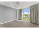 This well-lit bedroom boasts a large window, neutral carpet, elegant curtains, and contemporary track lighting at 3475 Oak Valley Road Ne # 870, Atlanta, GA 30326
