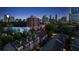 An aerial nighttime view of Brookhaven townhomes surrounded by lush greenery, with the city skyline in the distance at 3663 Brookhaven Manor Ne Xing, Atlanta, GA 30319