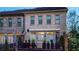 Charming three-story brick townhome featuring a private balcony, black railings, and manicured greenery at 3663 Brookhaven Manor Ne Xing, Atlanta, GA 30319