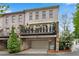 Townhome showcasing stone accents, a private balcony, and a two-car garage at 3663 Brookhaven Manor Ne Xing, Atlanta, GA 30319