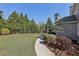 Lush backyard with a well-manicured lawn, mature trees, and a walkway along the side of the house at 403 Grassmeade Way, Snellville, GA 30078