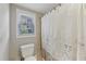 Cozy bathroom with a toilet, a window and a shower with a decorative curtain at 403 Grassmeade Way, Snellville, GA 30078