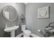 Stylish powder room with sleek fixtures, decorative mirror and neutral gray walls at 403 Grassmeade Way, Snellville, GA 30078