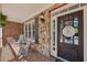 Inviting front porch with brick flooring, stone walls, rocking chairs, and a charming welcome sign on the front door at 403 Grassmeade Way, Snellville, GA 30078