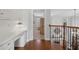 Upstairs hallway featuring hardwood floors, a built-in desk, with views of the living room and backyard at 403 Grassmeade Way, Snellville, GA 30078