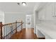 Hallway with wood floors, desk, cabinets, and an iron and wood banister at 403 Grassmeade Way, Snellville, GA 30078