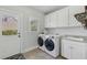 Well-equipped laundry room with modern washer and dryer, sink, and cabinets, offering convenience at 403 Grassmeade Way, Snellville, GA 30078