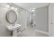Charming powder room with a pedestal sink, decorative mirror, and neutral decor at 403 Grassmeade Way, Snellville, GA 30078