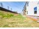 A spacious backyard featuring a gradual slope and a partial view of the home's exterior with brick foundation at 4202 Adler Cir, Buford, GA 30519