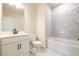 A modern bathroom with white marble tile, white vanity, and updated fixtures at 4202 Adler Cir, Buford, GA 30519