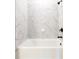 Bathroom featuring white marble tile, white tub, and black fixtures at 4202 Adler Cir, Buford, GA 30519