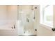 Modern bathroom featuring a tiled shower with glass door, bench, and soaking tub at 4202 Adler Cir, Buford, GA 30519