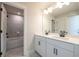 Elegant bathroom featuring double sinks, white cabinetry, and a view of the bathtub and shower at 4202 Adler Cir, Buford, GA 30519