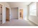 Bright bedroom with neutral carpet, two doors, and a window for natural light at 4202 Adler Cir, Buford, GA 30519