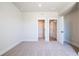 Large bedroom with neutral carpet and walls, along with an entrance to the hallway and closet at 4202 Adler Cir, Buford, GA 30519