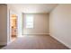 Neutral carpeted bedroom with ensuite bathroom and one window for ample light at 4202 Adler Cir, Buford, GA 30519