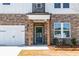 Inviting front entry featuring a modern door with glass panes, brick columns, and stylish lighting at 4202 Adler Cir, Buford, GA 30519