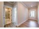 Hallway with wood floors leads to a bathroom with white marble shower and glass door at 4202 Adler Cir, Buford, GA 30519