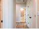 Hallway with doors leading to bathroom, wood floors, and neutral walls at 4202 Adler Cir, Buford, GA 30519