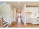 Open hallway featuring modern flooring, leading to kitchen, stairs to the upper level at 4202 Adler Cir, Buford, GA 30519