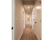 Hallway with wood floors and white doors leading to various rooms, including a bathroom at 4202 Adler Cir, Buford, GA 30519