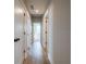 Hallway with multiple doors, hardwood floors, and neutral-colored walls at 4202 Adler Cir, Buford, GA 30519