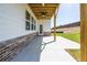 Covered patio with fan, leading to backyard with white vinyl siding and brick foundation at 4202 Adler Cir, Buford, GA 30519