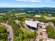 A scenic aerial shot highlights the outdoor amphitheater surrounded by lush green landscape and nearby modern buildings at 11302 Musette Cir, Alpharetta, GA 30009