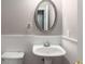 Cozy powder room featuring a pedestal sink and a decorative mirror at 11302 Musette Cir, Alpharetta, GA 30009