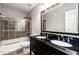 Modern bathroom featuring double sinks with granite countertops and tiled walk-in shower at 11302 Musette Cir, Alpharetta, GA 30009