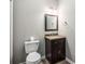 A half bathroom featuring dark wood vanity cabinet with a marble countertop at 11302 Musette Cir, Alpharetta, GA 30009